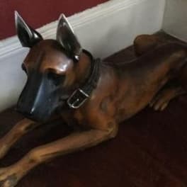 A brown dog sculpture lying on a dark surface