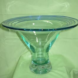 Blue glass pedestal bowl on a green cloth