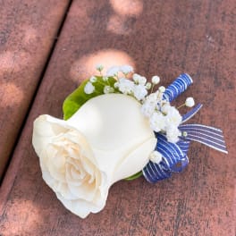 White rose boutonniere with baby's breath and blue ribbon accents