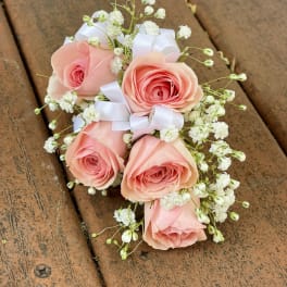 Small bouquet of pink roses with white baby's breath and ribbon
