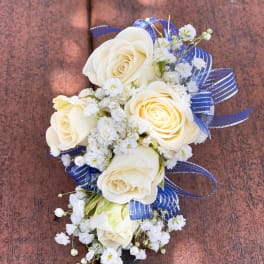 White rose corsage with baby's breath and blue ribbon