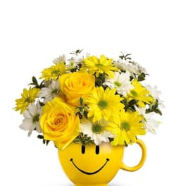 Yellow roses and daisies in a smiley-face mug