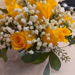 Yellow roses with white baby's breath in a glass vase