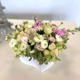 Pastel bouquet of roses and ranunculus in a white vase