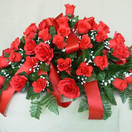 Red rose arrangement with red ribbons and greenery