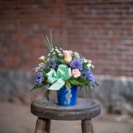 Mixed bouquet in a blue vase with a mint ribbon bow