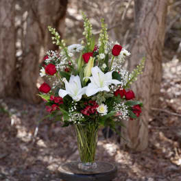 Bouquet of red roses and white lilies in a clear glass vase
