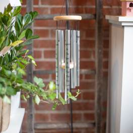 Hanging silver wind chime with a wooden top and black cords