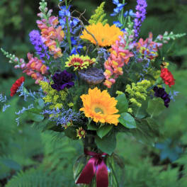 Mixed bouquet in a glass vase with bright yellow and purple flowers