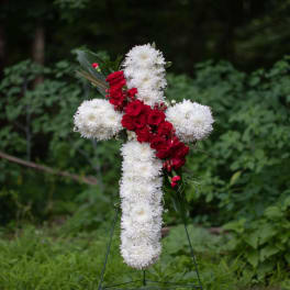 White and red floral cross on a stand