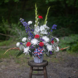 Tall red, white, and purple floral arrangement in a white vase