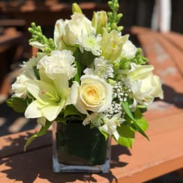 White floral arrangement in a square glass vase