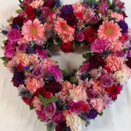 Heart-shaped floral wreath with pink, red, and purple blooms
