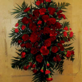 Large red rose and carnation spray with dark greenery