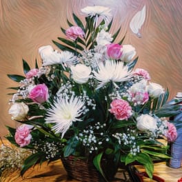 Pink and white floral arrangement in a wicker basket
