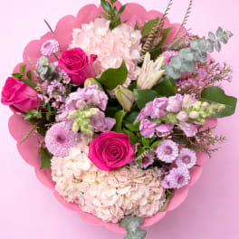 Pink and lavender bouquet with roses and hydrangeas on a pink background