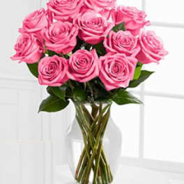 Pink roses arranged in a clear glass vase