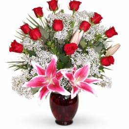 Red roses and pink lilies arranged in a dark red vase
