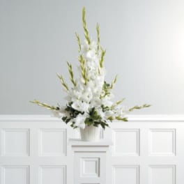 White floral arrangement in a ribbed vase on a pedestal