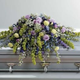 Large floral spray on a casket with purple and yellow flowers