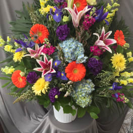 Colorful mixed flower arrangement in a white vase