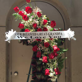 Standing sympathy spray of red roses with a memorial ribbon