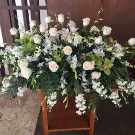 Casket arrangement of pale peach roses and dendrobium orchids