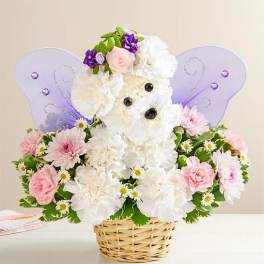 White and pink flower arrangement in a wicker basket with purple butterfly wings