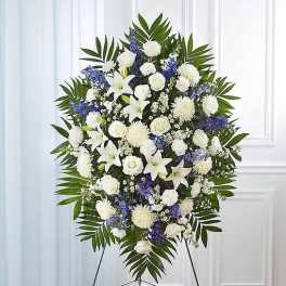 Standing floral spray of white and blue flowers on an easel