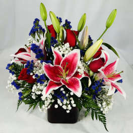 Bouquet of red roses and pink lilies in a black vase