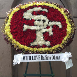 Large red and white floral standing wreath on an easel with a ribbon banner