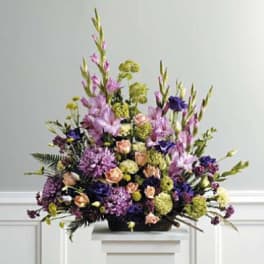 Large mixed floral arrangement in purple, peach, and green tones
