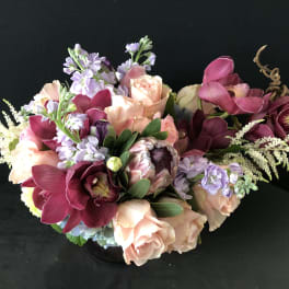 Bouquet of peach roses, burgundy orchids, and lavender flowers