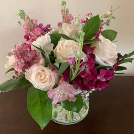 Bouquet of cream roses and pink flowers in a clear glass vase