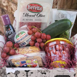 Gift basket with salami, cheese, grapes, basil, cucumber, and crackers
