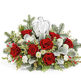 Red roses and white flowers arranged with an angel ornament