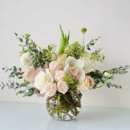 Blush and white floral arrangement in a clear glass vase