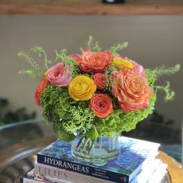 Colorful bouquet of roses and hydrangeas in a clear glass vase