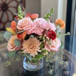 Pink and peach flower arrangement in a clear glass vase