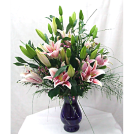 Pink lilies arranged in a dark glass vase