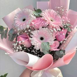 Pink gerbera daisy and rose bouquet wrapped in pastel paper