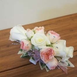 Small bouquet of white and blush roses with ribbon and jeweled picks