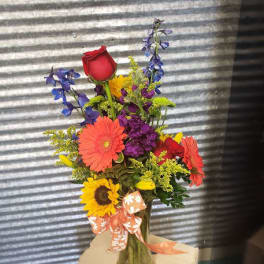 Colorful mixed bouquet in a glass vase with a ribbon