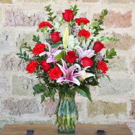 Red roses and pink lilies in a glass vase