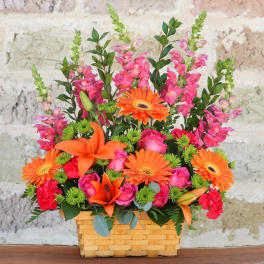 Basket arrangement with orange lilies, gerbera daisies, and pink roses