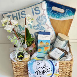 Gift basket with orchids, candles, cookies, and beach-themed towels