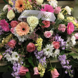 Large pink, white, and lavender floral spray with a "Beloved Wife" ribbon