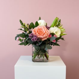 Bouquet of peach and white flowers in a clear glass vase