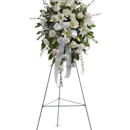 White floral standing spray on an easel with ribbon