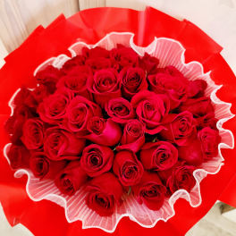 Bouquet of red roses wrapped in bright red paper